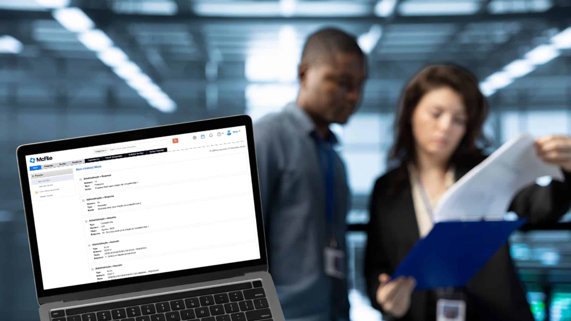 Laptop screen displaying code in a data center environment, with two professionals reviewing printed documents in the background